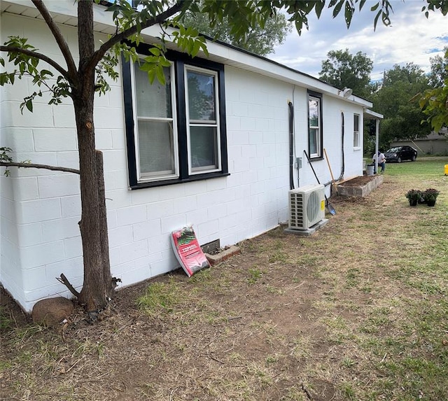 view of home's exterior featuring a lawn and ac unit