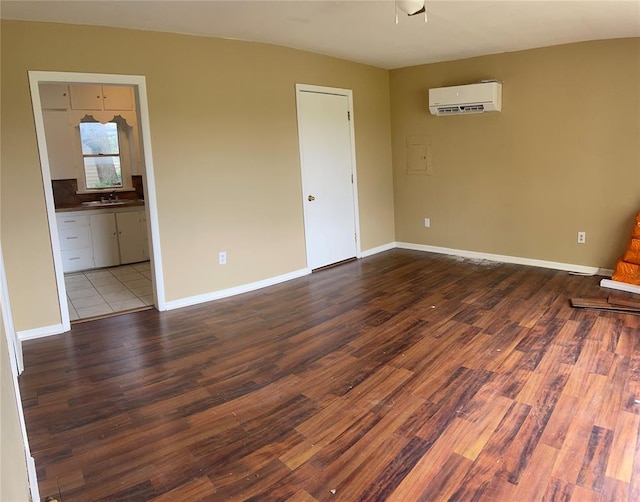 spare room with sink, a wall mounted air conditioner, and hardwood / wood-style flooring