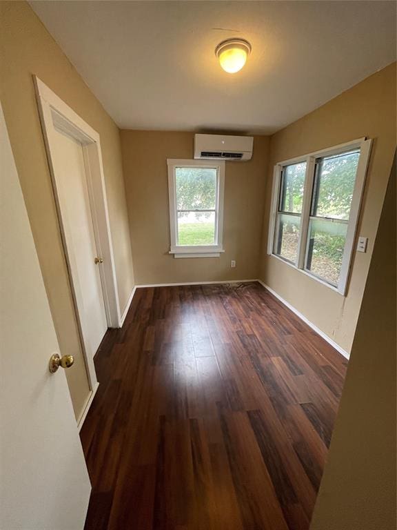 empty room featuring dark hardwood / wood-style floors and a wall unit AC