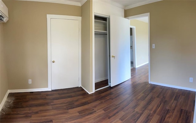 unfurnished bedroom with crown molding, a closet, dark wood-type flooring, and a wall unit AC