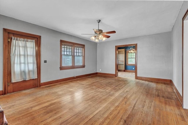 empty room featuring light wood finished floors, ceiling fan, and baseboards