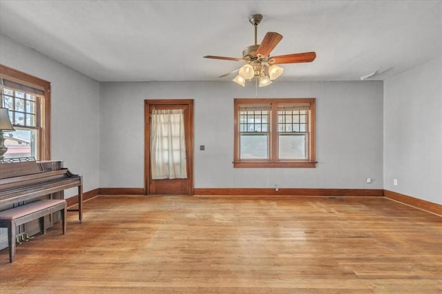 entryway featuring baseboards, light wood-style flooring, and a ceiling fan