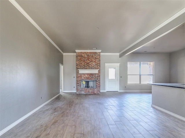 unfurnished living room featuring wood-type flooring, a brick fireplace, and ornamental molding