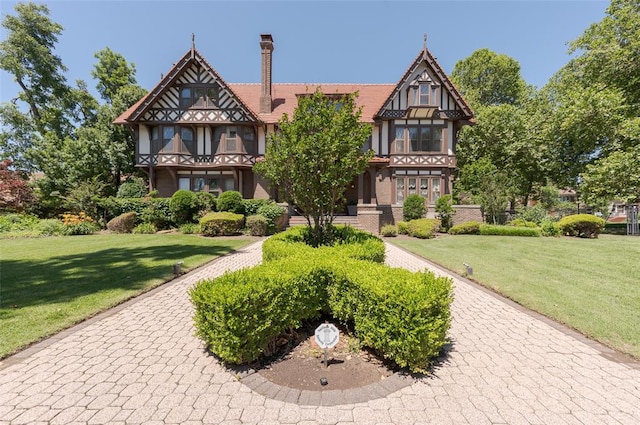 tudor home featuring a front lawn