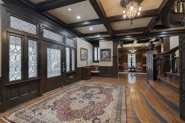 foyer featuring an inviting chandelier, plenty of natural light, and coffered ceiling