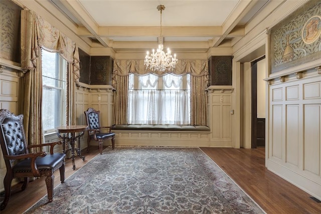 sitting room featuring beam ceiling, coffered ceiling, dark hardwood / wood-style floors, and an inviting chandelier