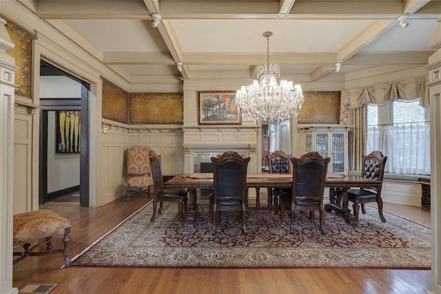 dining room featuring hardwood / wood-style floors, beam ceiling, coffered ceiling, and a notable chandelier