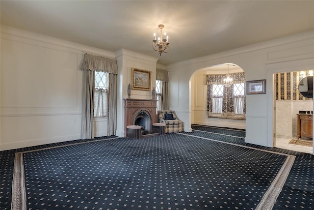 unfurnished living room featuring carpet flooring and a notable chandelier