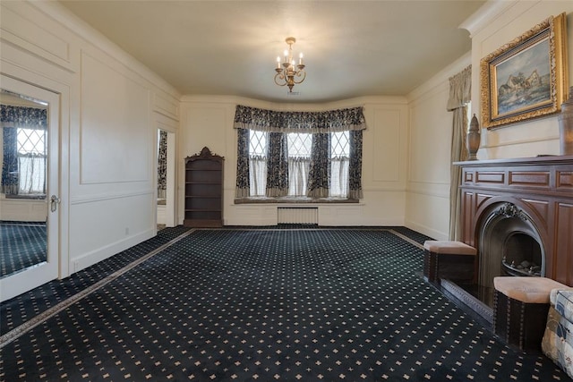 interior space with radiator, carpet floors, a healthy amount of sunlight, and a notable chandelier