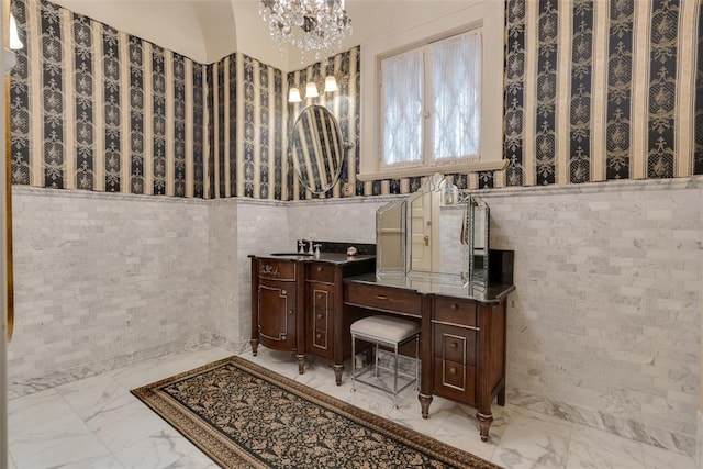 bathroom with vanity, tile walls, and an inviting chandelier