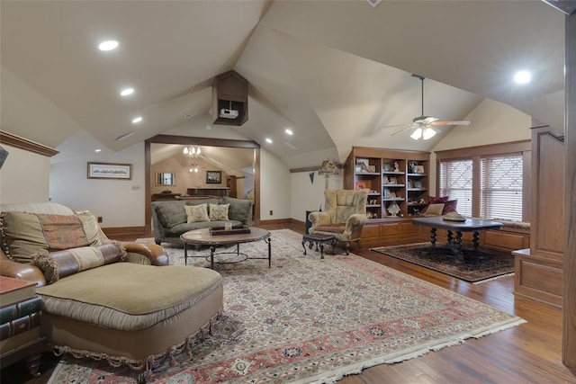 living room with wood-type flooring, vaulted ceiling, and ceiling fan