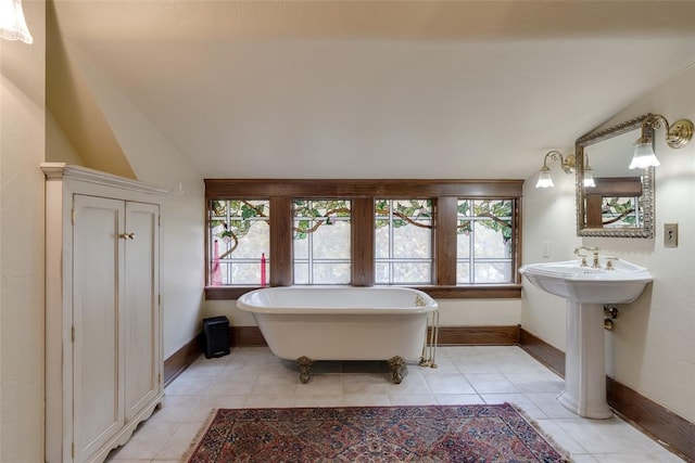 bathroom with tile patterned floors, lofted ceiling, and a tub