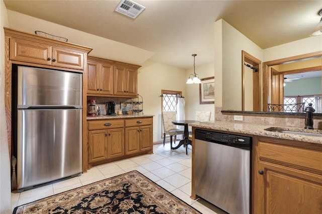 kitchen with light stone countertops, a wealth of natural light, sink, and stainless steel appliances