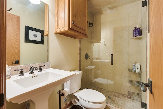 bathroom with toilet, walk in shower, and sink