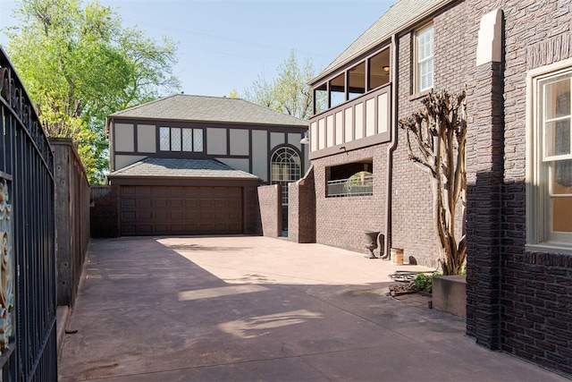 exterior space with a garage, an outdoor structure, and a balcony