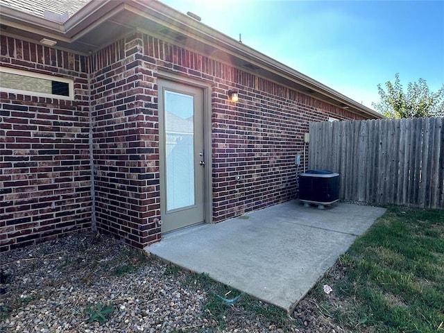 property entrance featuring central air condition unit and a patio area