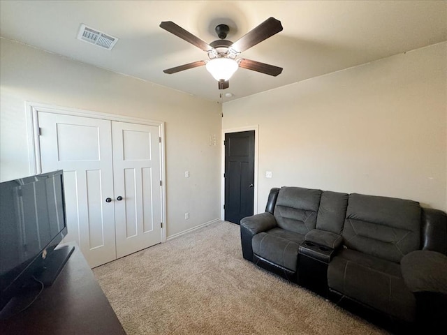 carpeted living room with ceiling fan