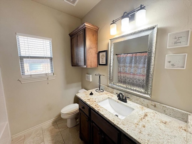 bathroom with tile patterned flooring, vanity, and toilet