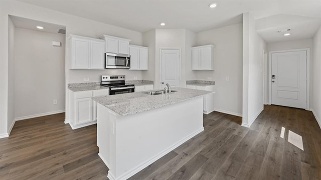 kitchen with appliances with stainless steel finishes, white cabinets, a sink, and a center island with sink