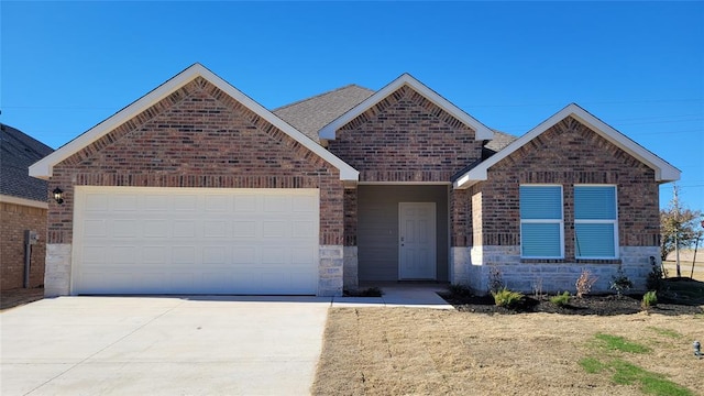 ranch-style home with brick siding, a shingled roof, concrete driveway, an attached garage, and stone siding