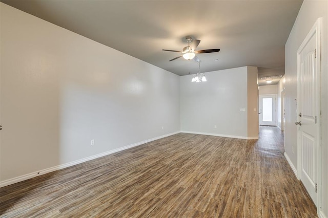 empty room featuring wood-type flooring and ceiling fan with notable chandelier