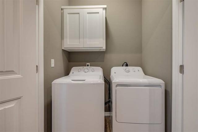 washroom featuring washing machine and clothes dryer and cabinets