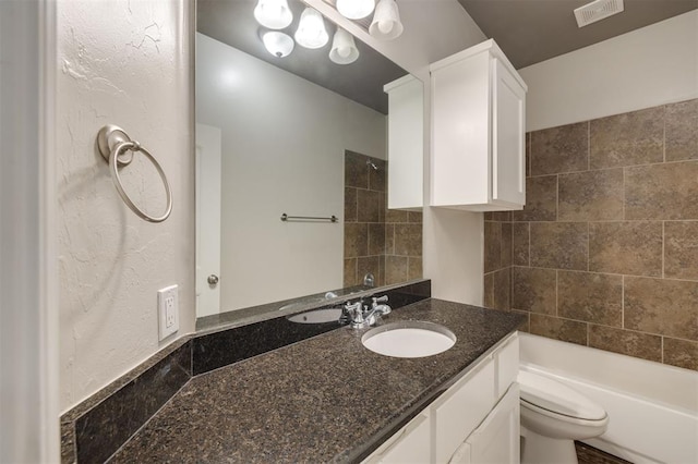 full bathroom featuring tiled shower / bath, vanity, and toilet