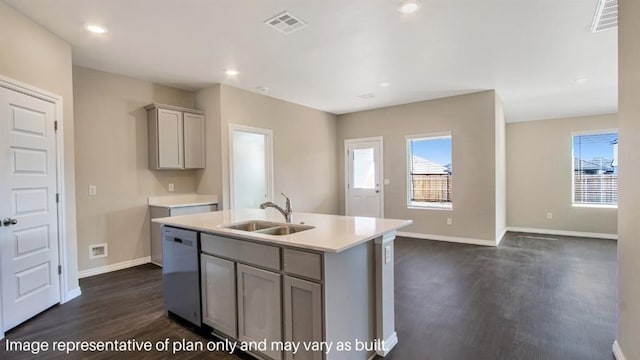 kitchen featuring a center island with sink, dishwasher, gray cabinets, light countertops, and a sink