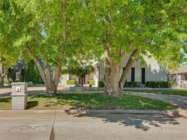 view of property hidden behind natural elements with a front yard