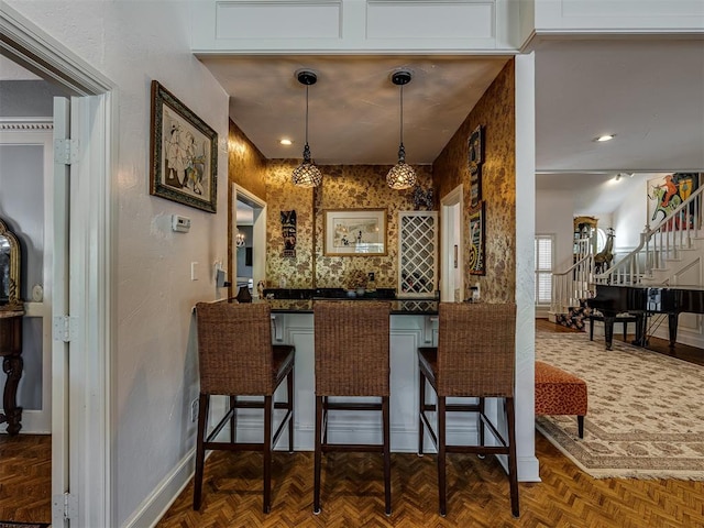 bar featuring pendant lighting and dark parquet flooring