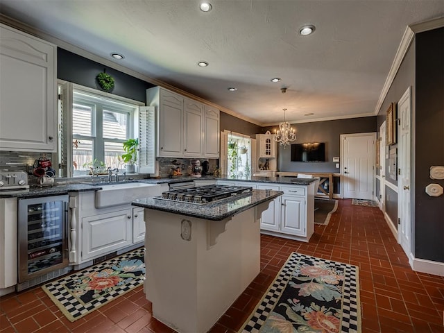 kitchen featuring wine cooler, a healthy amount of sunlight, a center island, and hanging light fixtures