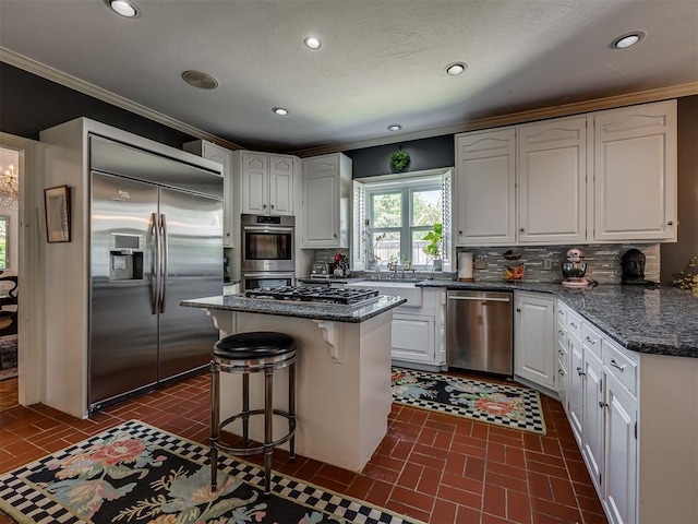 kitchen with a center island, stainless steel appliances, white cabinetry, and tasteful backsplash