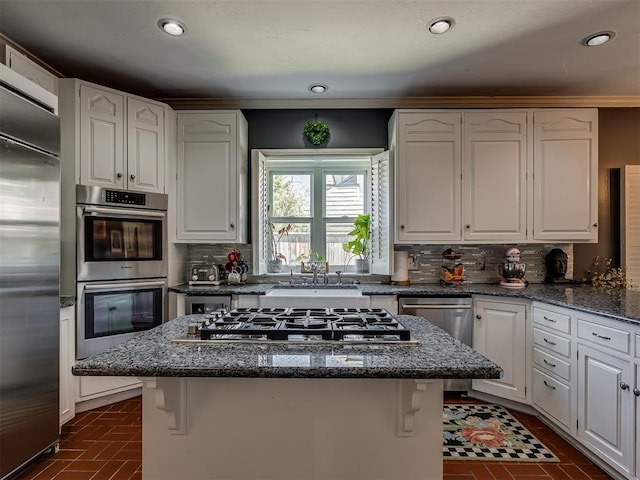 kitchen featuring a kitchen island, white cabinetry, appliances with stainless steel finishes, and tasteful backsplash