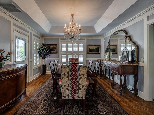 dining room with dark parquet floors, an inviting chandelier, and a tray ceiling