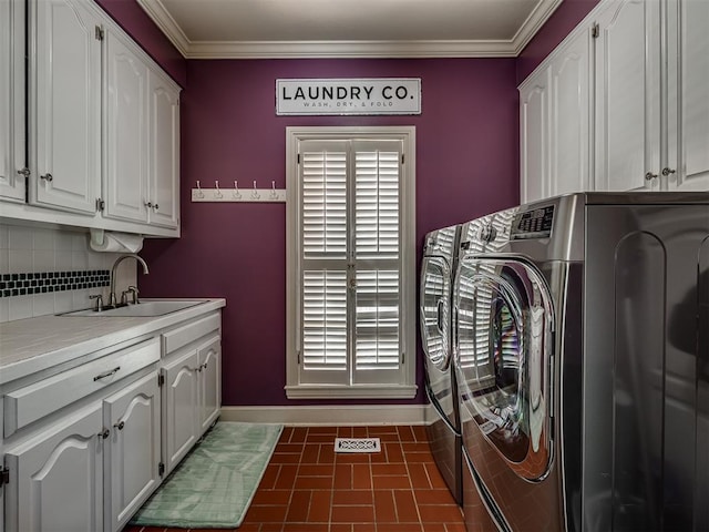 laundry area featuring crown molding, cabinets, separate washer and dryer, and sink