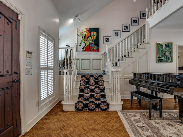 entrance foyer with high vaulted ceiling and parquet flooring