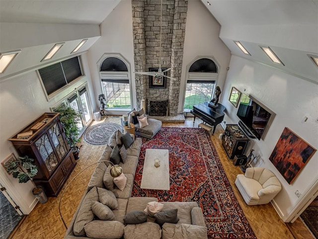 living room featuring a stone fireplace and high vaulted ceiling