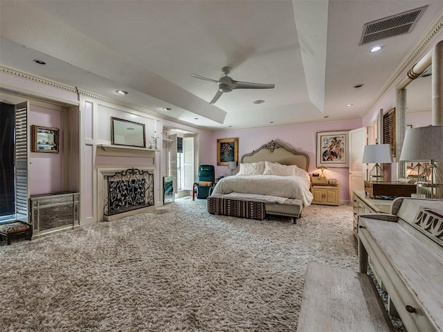 carpeted bedroom featuring ceiling fan, a raised ceiling, and ornamental molding