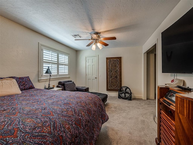 carpeted bedroom with ceiling fan and a textured ceiling