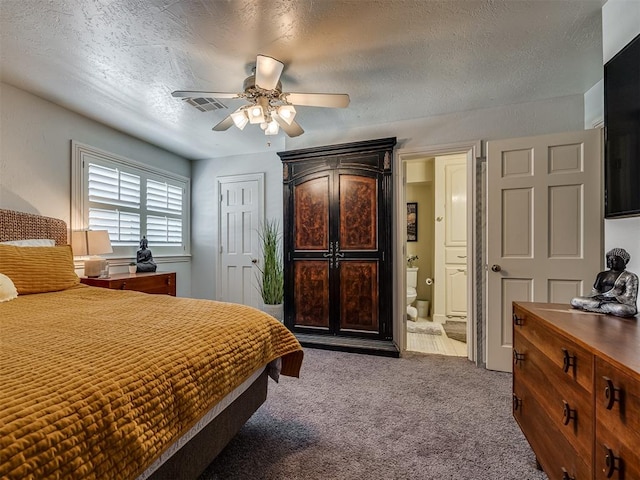 carpeted bedroom featuring ceiling fan, ensuite bathroom, and a textured ceiling