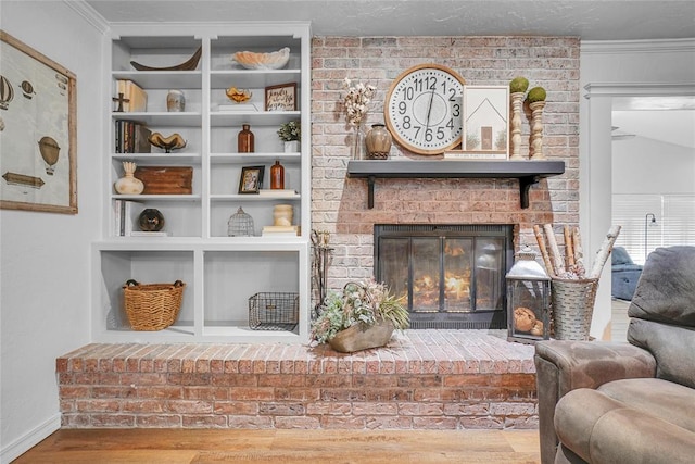 living area featuring hardwood / wood-style floors, lofted ceiling, a brick fireplace, and crown molding