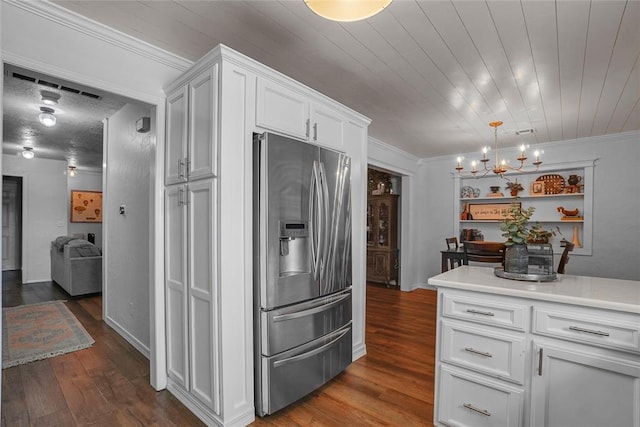 kitchen featuring dark wood-type flooring, white cabinets, crown molding, stainless steel refrigerator with ice dispenser, and a chandelier