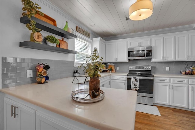 kitchen featuring crown molding, decorative backsplash, light wood-type flooring, appliances with stainless steel finishes, and white cabinetry