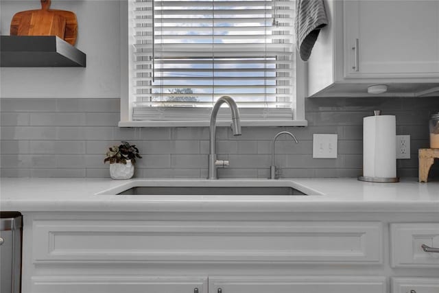 room details featuring tasteful backsplash, white cabinetry, and sink