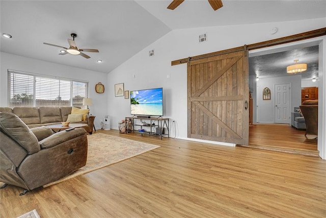 living room with a barn door, ceiling fan, light hardwood / wood-style floors, and lofted ceiling