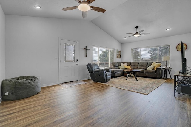 living room with hardwood / wood-style flooring, ceiling fan, and high vaulted ceiling