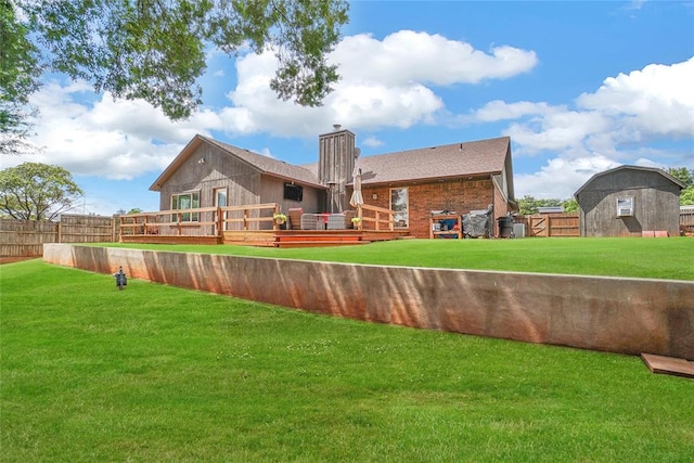 back of house featuring a lawn and a wooden deck