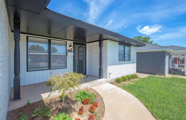 entrance to property featuring a lawn