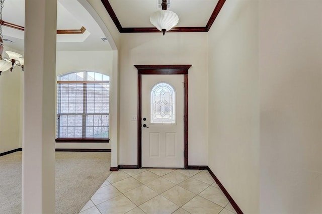 entrance foyer with light colored carpet, a wealth of natural light, and crown molding