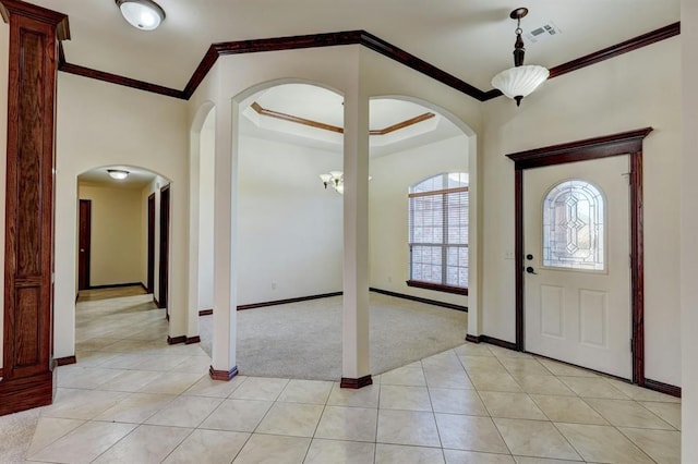 carpeted entryway with ornamental molding and a notable chandelier